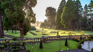 A formal garden with manicured lawns, a stone bridge, and tall trees. - Markree Castle (Collooney)