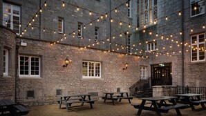 A courtyard with stone buildings, outdoor lighting, and picnic tables. - Markree Castle (Collooney)