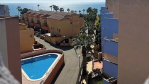 Un quartier résidentiel doté d’une piscine, de bâtiments et offrant une vue sur la mer.