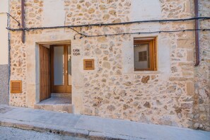 A stone building with a wooden door and a window.