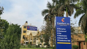 A Comfort Inn sign listing amenities including Reception, Restaurant, Bar, Washrooms, Breeze Café, and Conference Hall. - Comfort Inn Coral River (Pathankot)