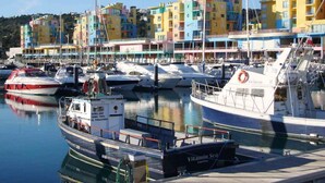 Un port de plaisance avec des bâtiments aux couleurs vives et des bateaux amarrés.
