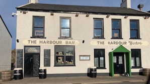 Een gebouw met borden voor 'The Harbour Bar' en 'The Harbour Bistro'.