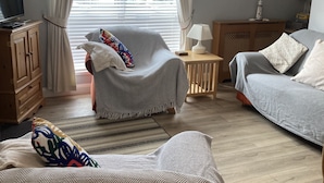 Een gezellige slaapkamer met een bed, twee stoelen, een houten kast en een kleine tafel.