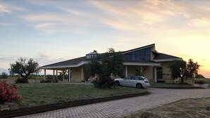 Ein modernes Haus mit überdachter Veranda, einer Auffahrt und einem davor geparkten Auto.