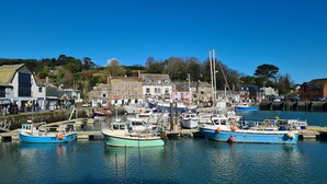 Un puerto con barcos amarrados, edificios a lo largo de la costa y un cielo azul despejado.