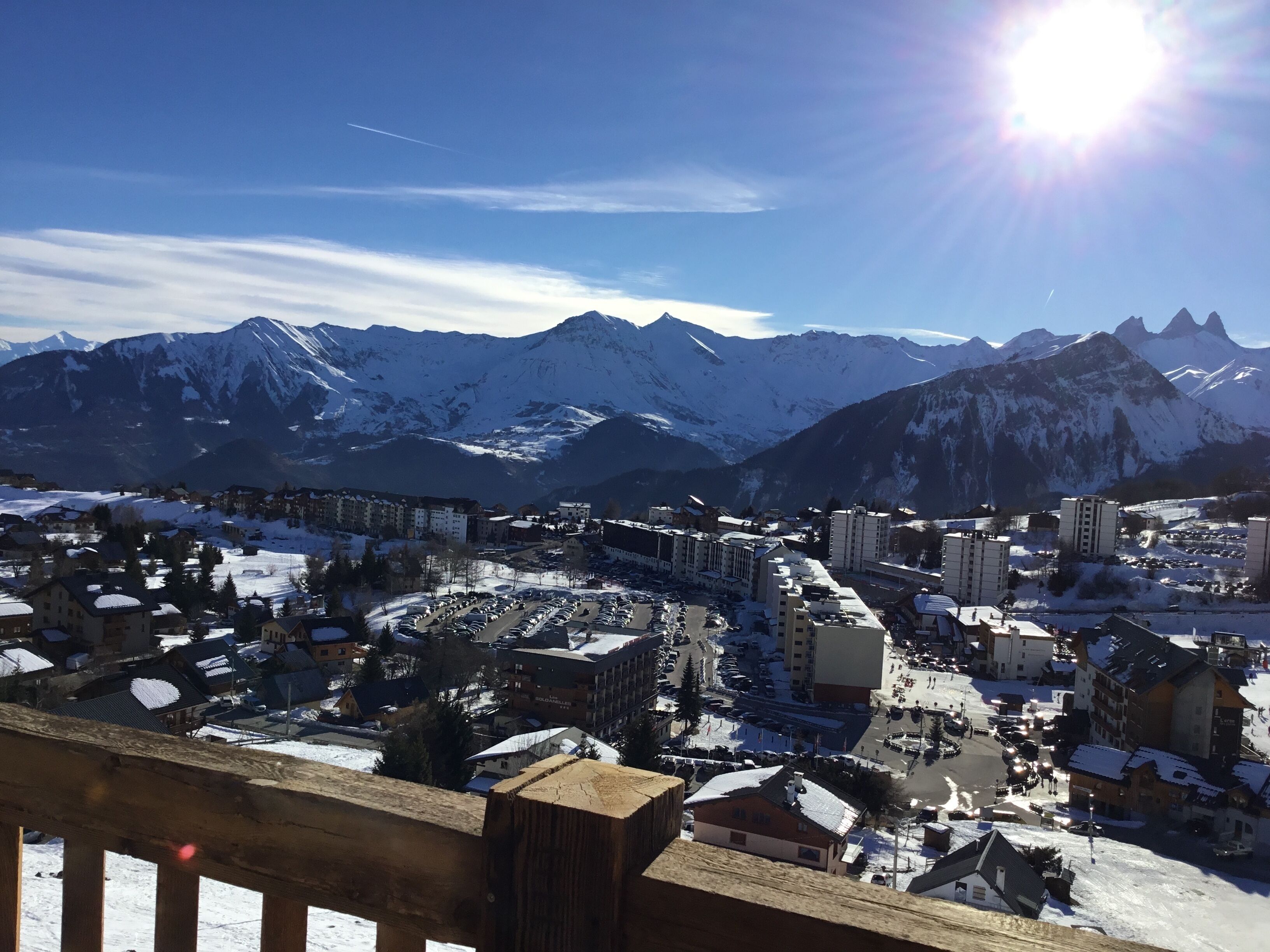 Une ville de montagne enneigée, avec des bâtiments et un parking.