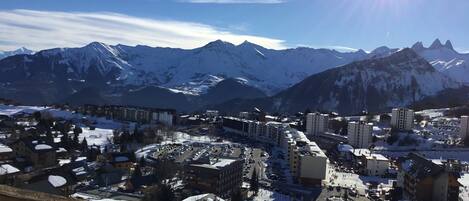 A snow-covered mountain town with buildings and a parking lot.