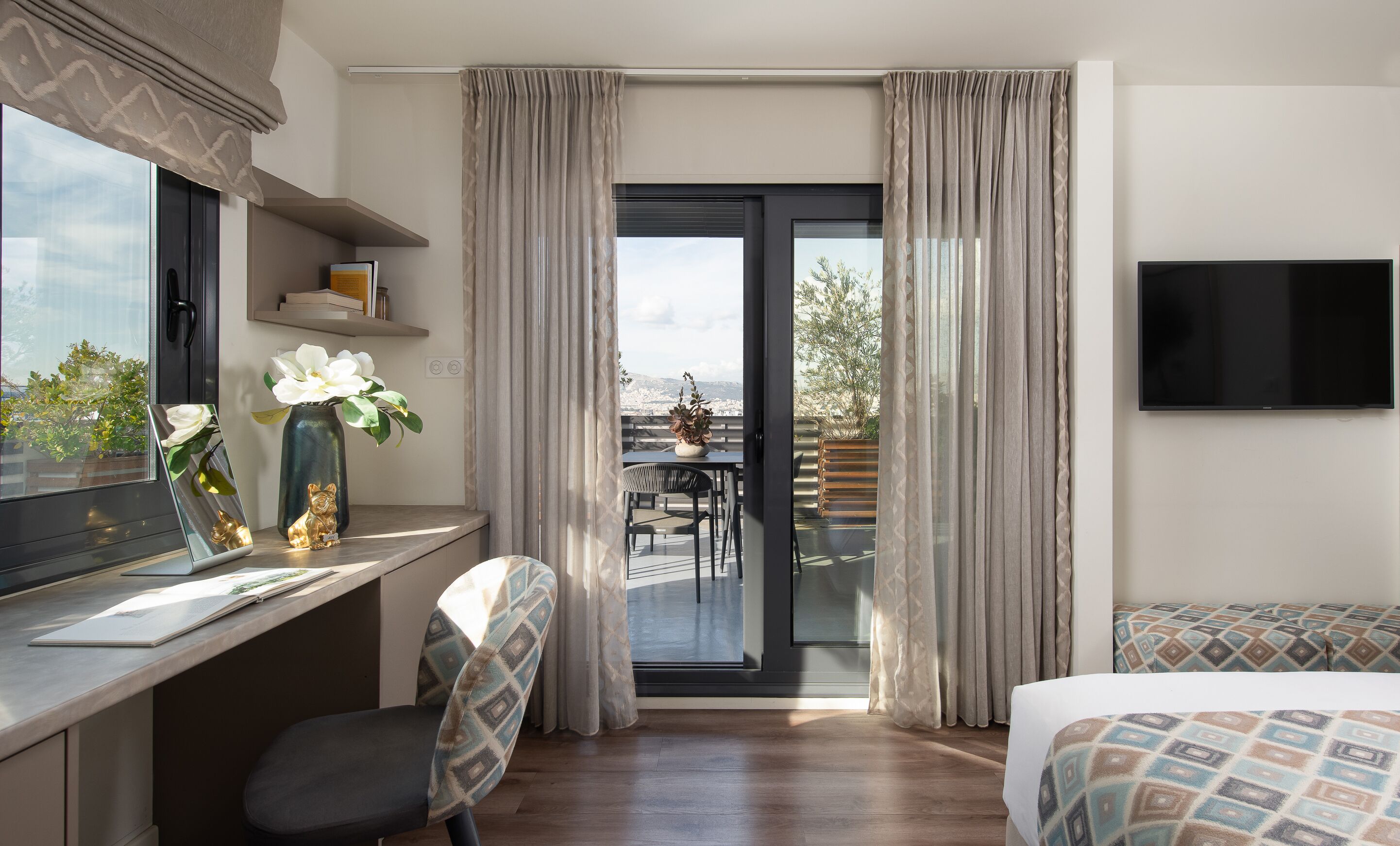 A modern hotel room with a desk, chair, and two beds.