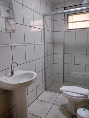 Standaard driepersoonskamer, meerdere bedden | Badkamer | Een douche, handdoeken, zeep, shampoo