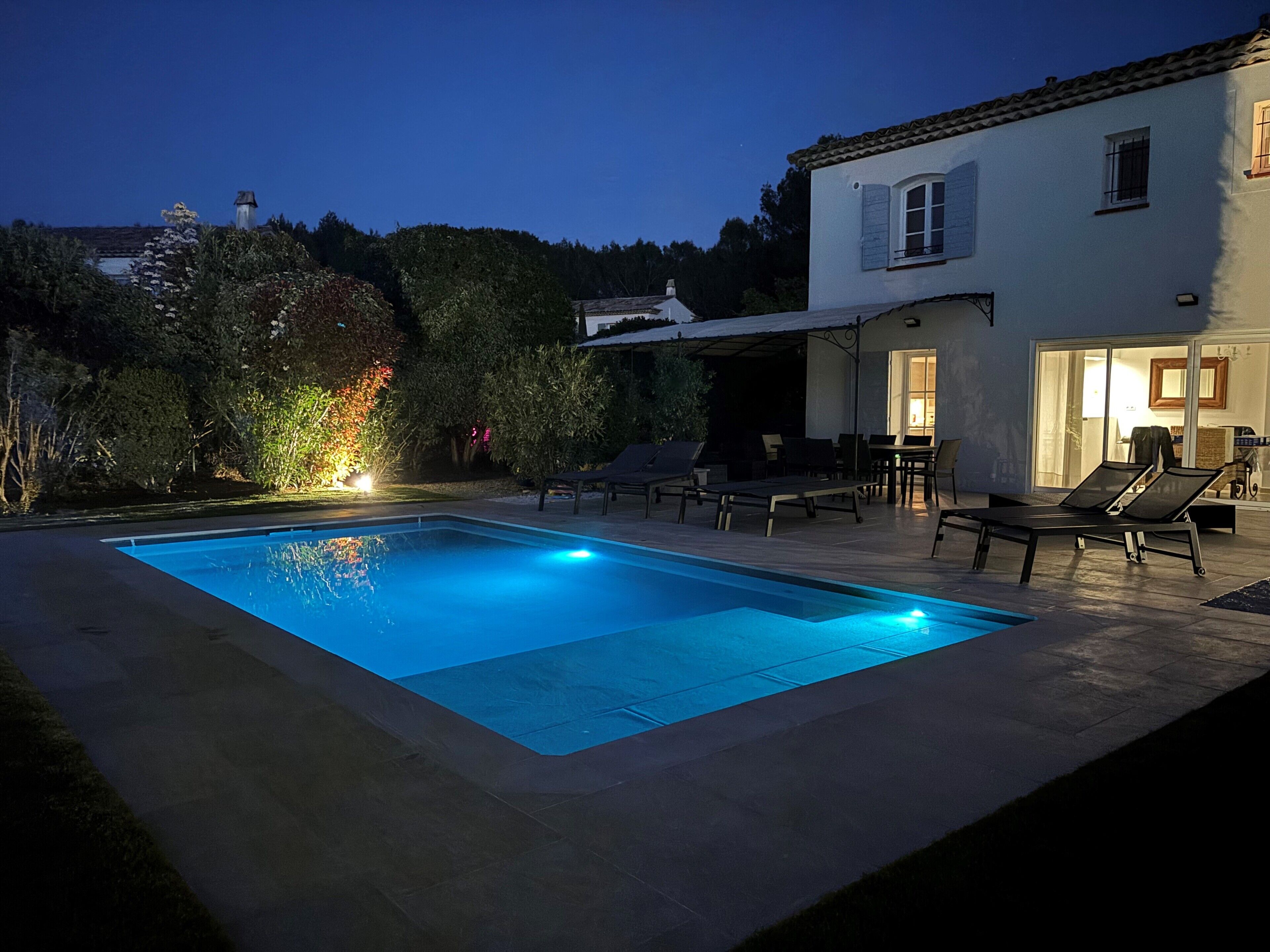 A swimming pool with lounge chairs and a patio area.