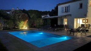 A swimming pool with lounge chairs and a patio area.