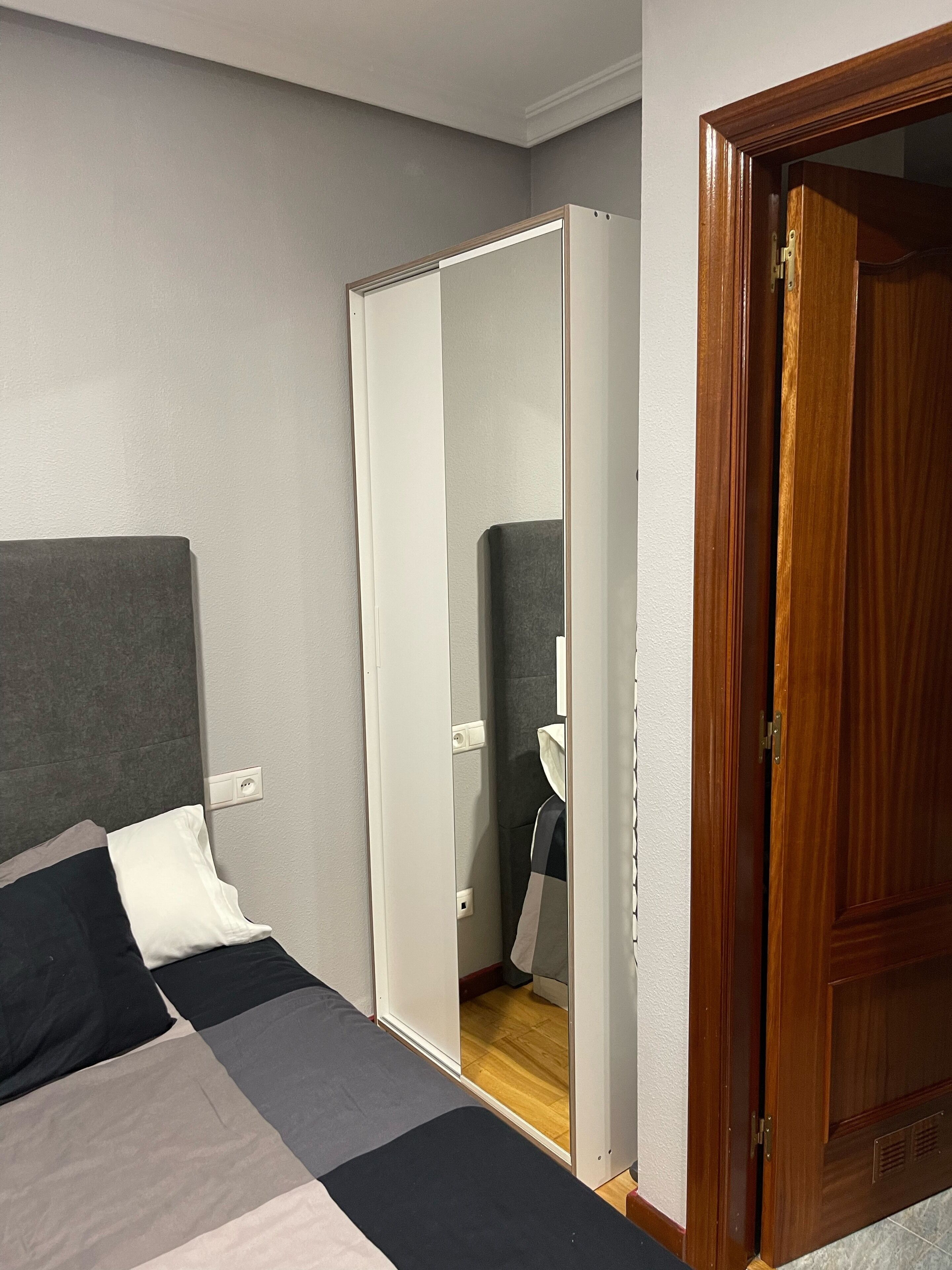 Une chambre à coucher avec un lit, une armoire et une porte.