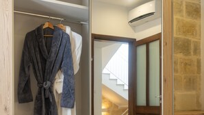 Quarto de hotel com uma cama grande, um guarda-roupa e um espelho.