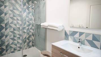 A bathroom with a shower, a sink, and a mirror.
