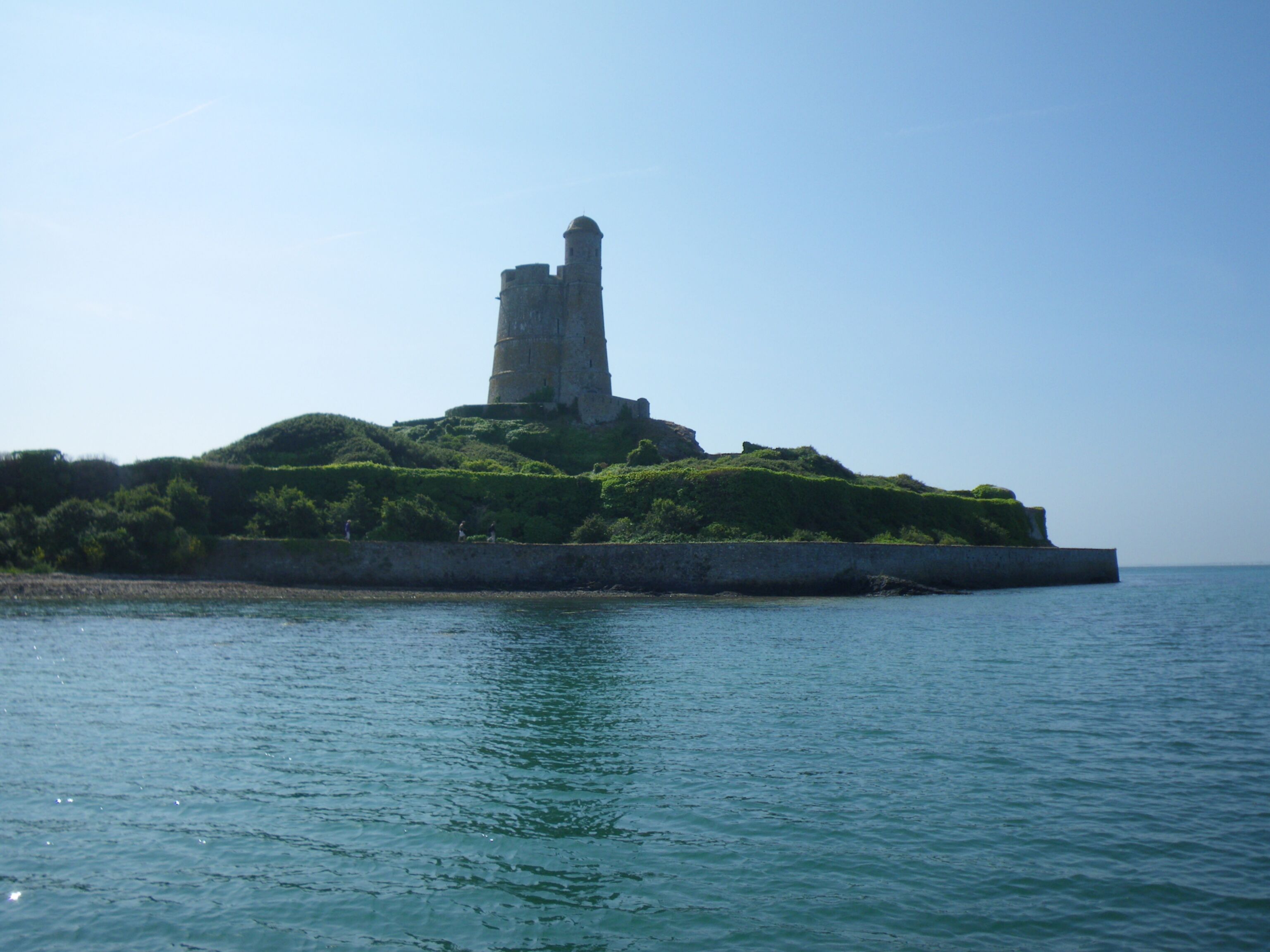 A historic stone tower on a small island surrounded by water.