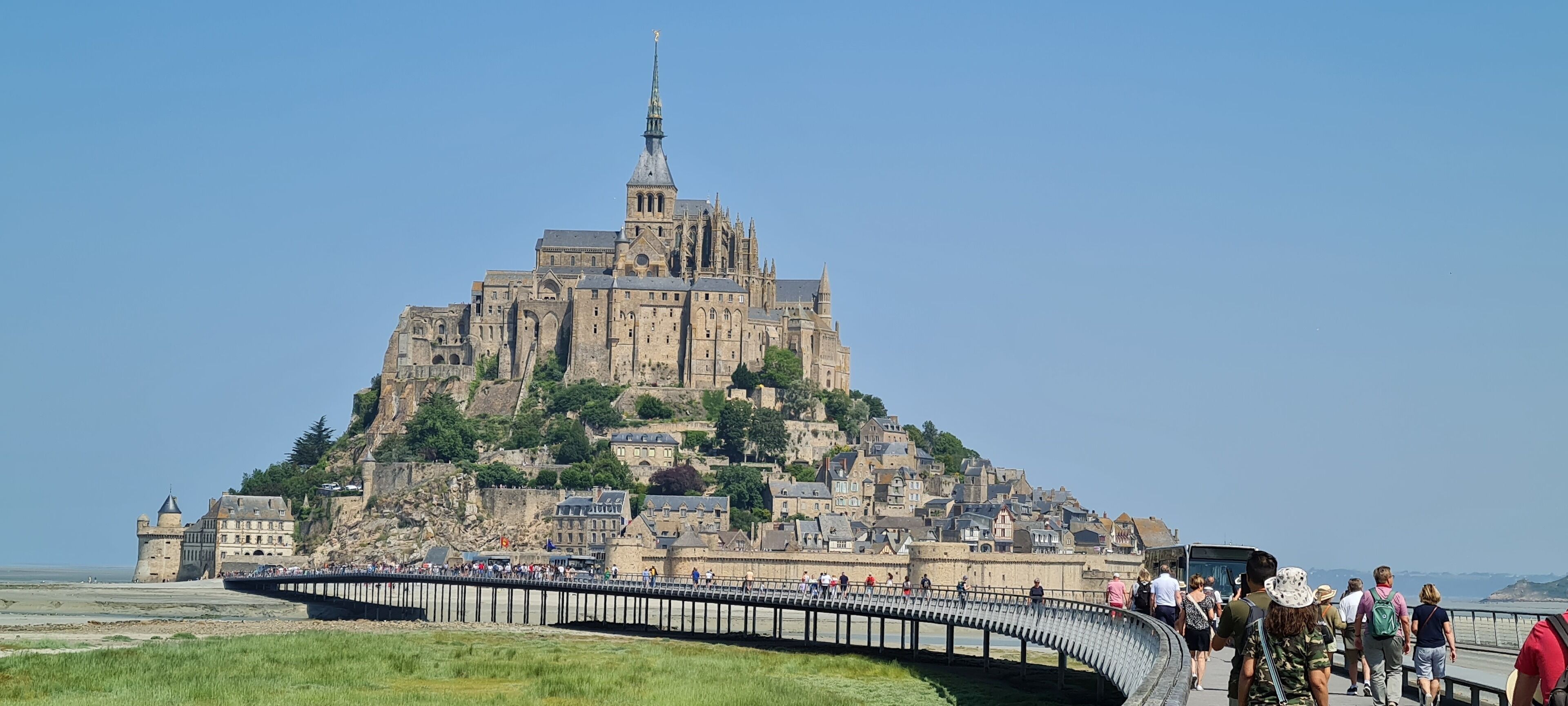 Eine historische Burg auf einem Hügel, verbunden durch eine Brücke.