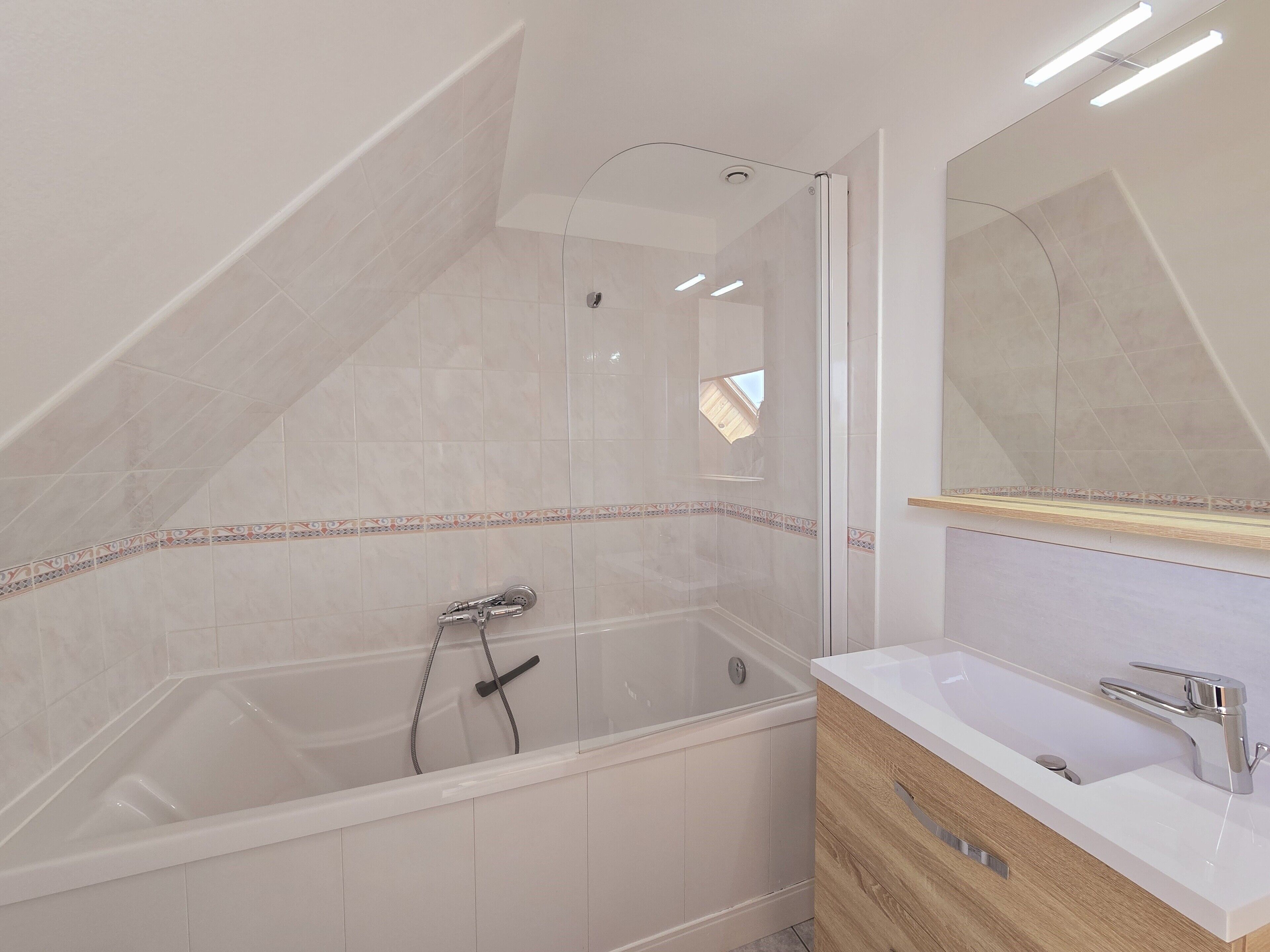 Ein modernes Badezimmer mit freistehender Badewanne, einem Waschtisch mit Spiegel und einer Duschkabine.