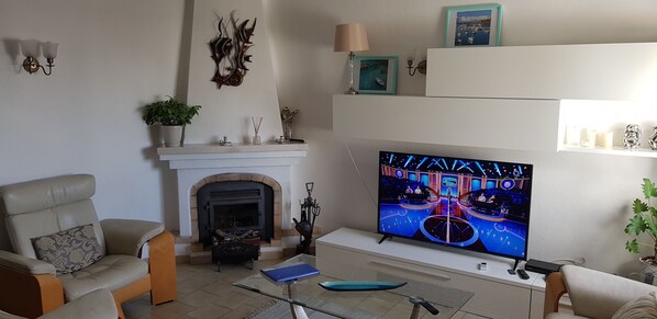 A living room with a fireplace, a television, and a sofa. - Holiday house with sea view (Carvoeiro)