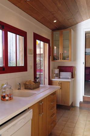 A kitchen with wooden cabinets, a microwave, and a coffee maker. - Idyllic chalet near the beach in Cap Ferret A0337 (Lège-Cap-Ferret)