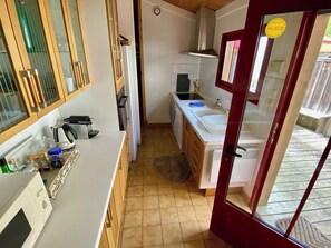 Una cocina compacta con microondas, estufa y armarios.