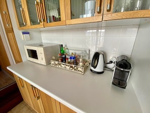 A kitchen with a microwave, a coffee maker, a kettle, and a spice rack. - Idyllic chalet near the beach in Cap Ferret A0337 (Lège-Cap-Ferret)