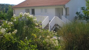A two-story house with a red-tiled roof, white exterior walls, and a small porch. - Apartment in Kampor with Seaview, Terrace, Air condition, WIFI (4610-2) (Kampor)