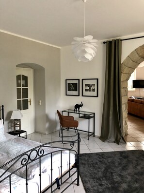 A bedroom with a bed, a desk, a chair, a lamp, and two framed pictures on the wall. - Vacation apartment in the Villa Graf von Pfeil on the banks of the Elbe (Neustadt)