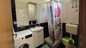 A compact bathroom with a washing machine, sink, toilet, and shower curtain. - Apartment in Medulin with Terrace, Air condition, WIFI, Washing machine (4634-5) (Medulin)