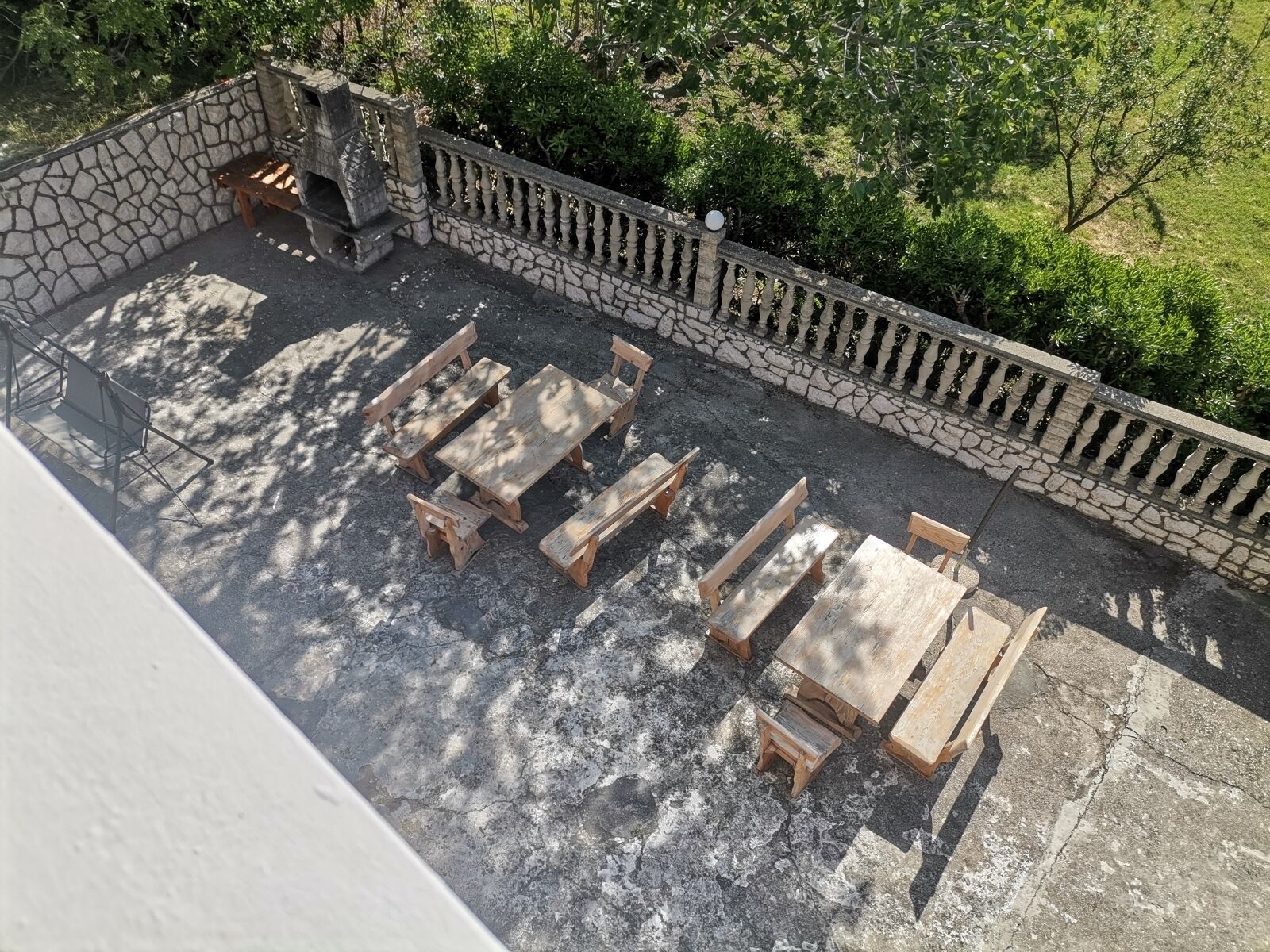 Un muro de piedra con un banco de madera y una mesa en un patio.