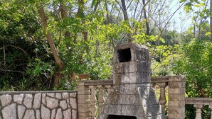 A stone-built outdoor oven with a bench and logs underneath, surrounded by a stone wall and greenery. - Apartment in Lopar with Terrace, Air condition, WIFI (4620-1) (Lopar)