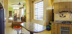 Una cocina con encimera de mármol, armarios de madera y horno empotrado.