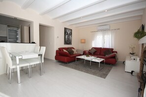 A modern living room with a dining area, red sofas, a coffee table, and a white dining table with chairs. - T-1118, Casa Blanca, newly renovated villa with many extras (Els Poblets)