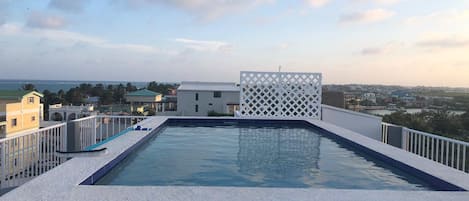 Una piscina al aire libre, sillones reclinables de piscina