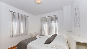 Villa familiar, varias camas, vistas al jardín | Colchones con acolchado adicional y tabla de planchar con plancha
