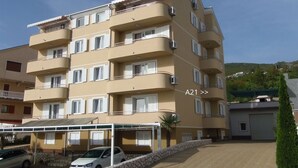 A multi-story apartment building with balconies, a covered parking area, and a clear sky. - Apartment in Dramalj with Seaview, Balcony, Air condition, WIFI (4623-2) (Dramalj)