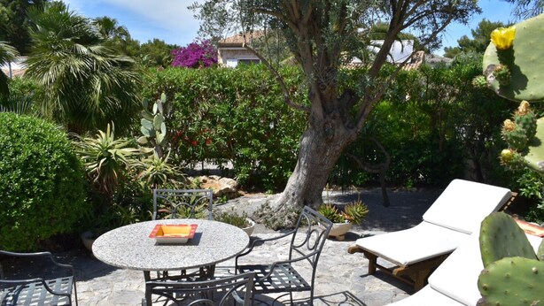 Un patio con una mesa redonda, sillas y sillones.
