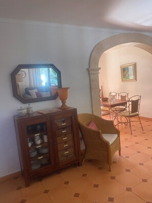 A dining area with a table, chairs, and a wicker chair. - Beautiful, quietly located vacation home in Bon Aire near Alcudia with sea views (Mal Pas-Bon Aire)