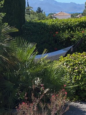 A garden with a hammock, lush greenery, and a view of distant mountains. - Beautiful, quietly located vacation home in Bon Aire near Alcudia with sea views (Mal Pas-Bon Aire)