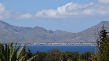 Een kuststad met bergen op de achtergrond en een heldere lucht.