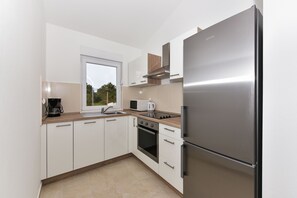 Departamento familiar (S4) | Cocina privada | Refrigerador con congelador, microondas, horno y parrilla de estufa