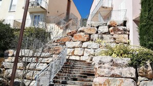 A stone staircase leading up to a building with a balcony.