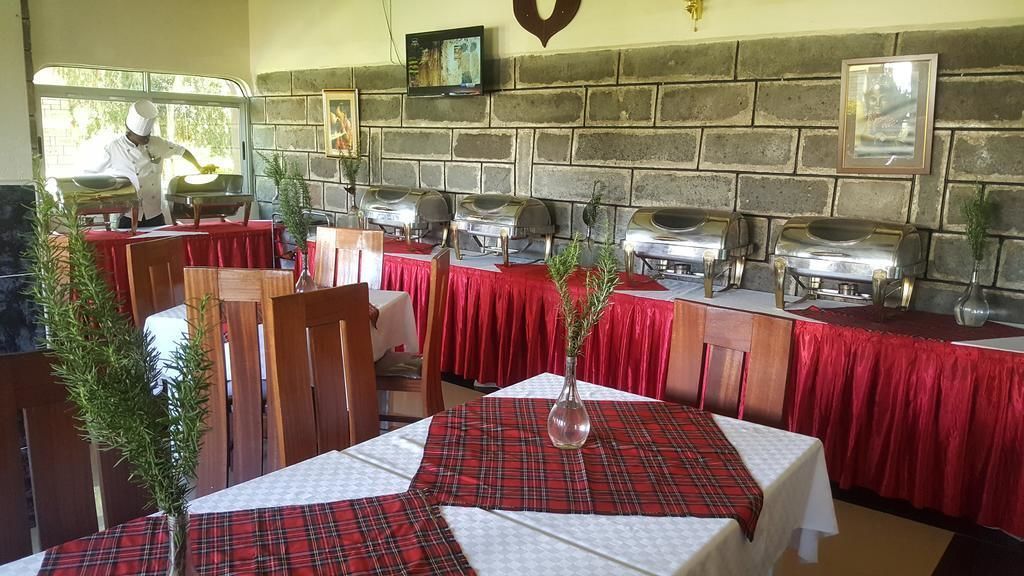 Un restaurante con varias mesas cubiertas con manteles a cuadros rojos y blancos, y equipado con parrillas de barbacoa.