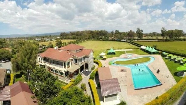 A residential area with a large house, a swimming pool, and a well-maintained lawn. - Lanet Matfam Resort (Nakuru)