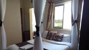 A neatly made bed with a white and purple bedspread, a white pillow, and a white canopy. - Lanet Matfam Resort (Nakuru)