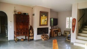 A spacious living room with a large wooden cabinet, a fireplace, a television, and a staircase. - EXCEPTIONAL site: SPACIOUS VILLA 8 BEDS, SWIMMING POOL 15x5M, SAUNA (Le Val)