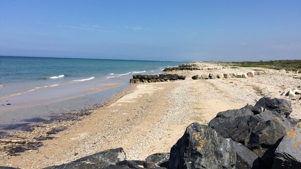 A beach with a rocky shoreline and calm sea. - Quai Ouest: 2/4p rental 100m from Goldbeach beach (Ver-sur-Mer)