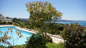 A swimming pool surrounded by lush greenery and a view of the sea. - 3 Rooms Apartment 65 m² + Terrace 28 m². 4 beds. Residence with Pool (Bandol)