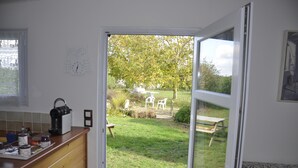 Een keuken met uitzicht op een tuin door een open deur.