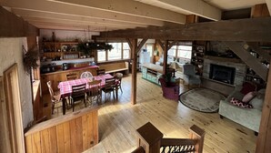 A rustic cabin interior with a dining area, kitchen, and seating space. - In-Town Moose Haus Lodge  (Clear Lake)